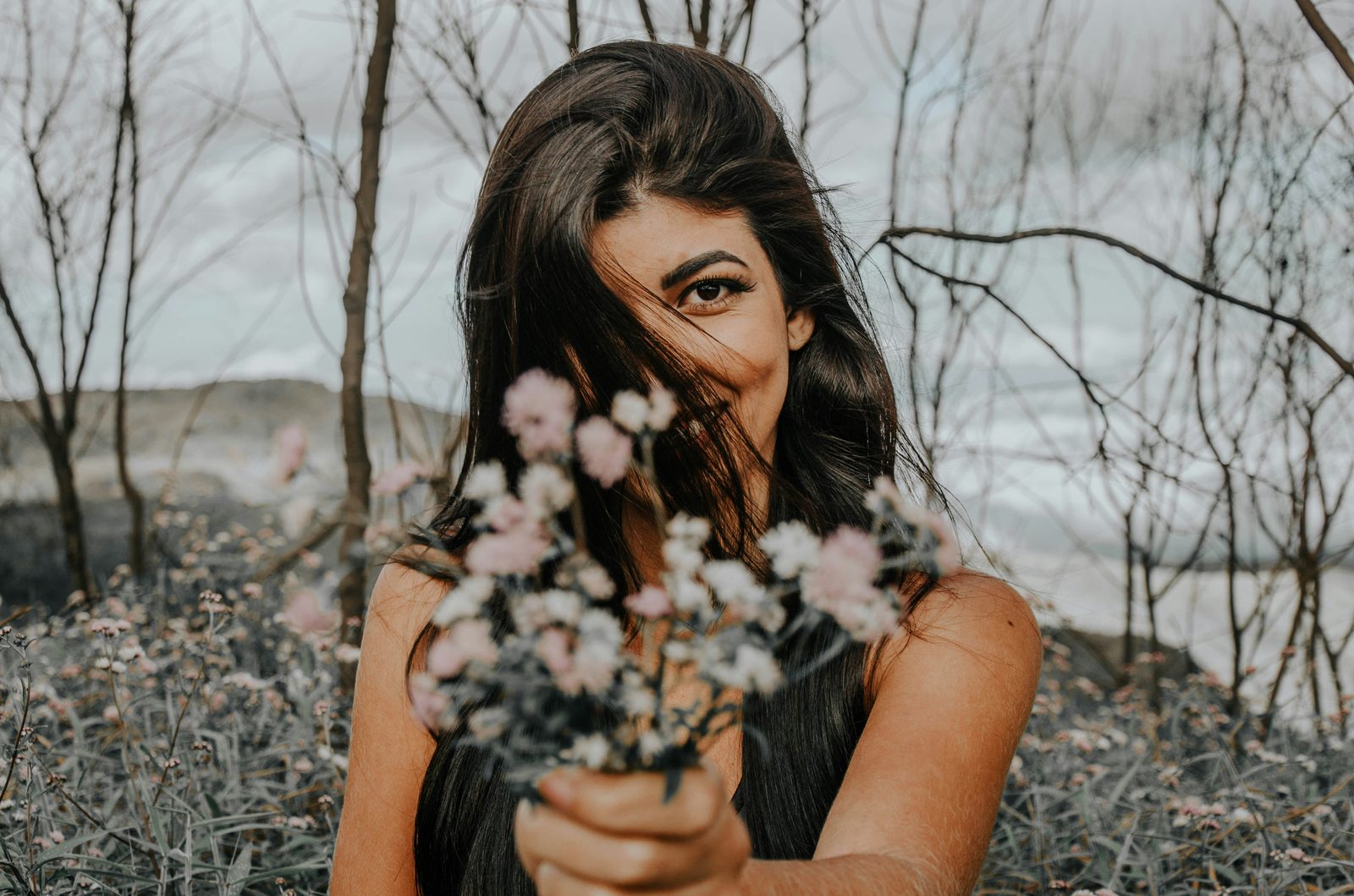 Femme tenant des fleurs, regard direct