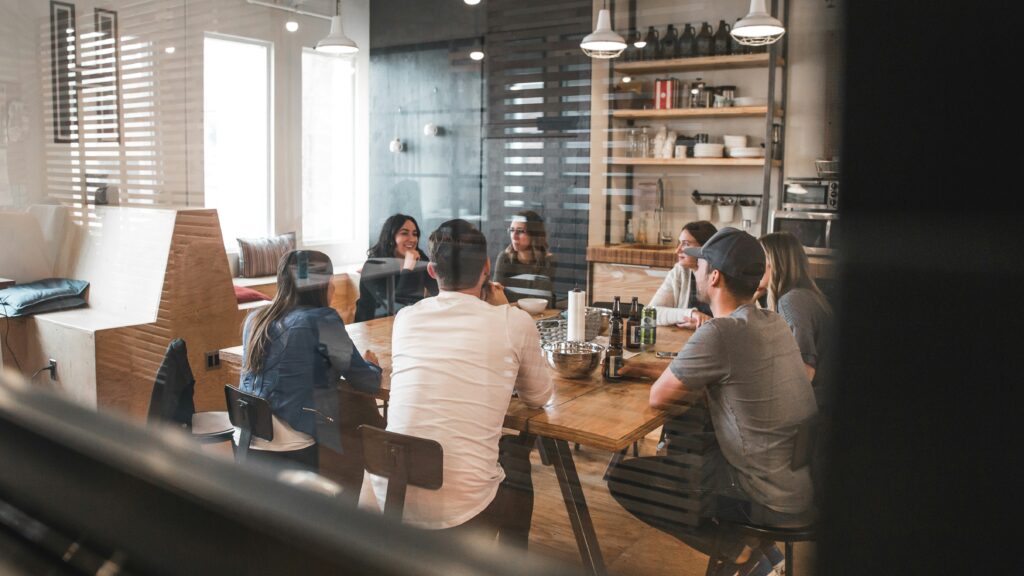 Groupe de personnes en discussion autour d'une table en bois