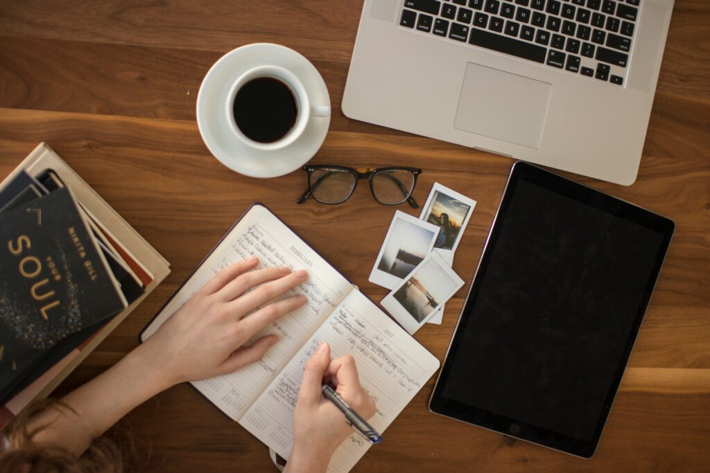 Carnet, café et ordinateur sur un bureau en bois